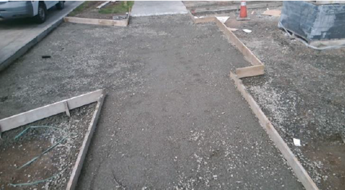 Driveway showing what it should look like ready for the vehicle crossing pre-pour inspection with base and wood frame ready for concrete to be poured.